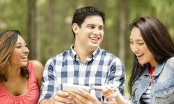 three young adults looking at phone three young adults looking at phone